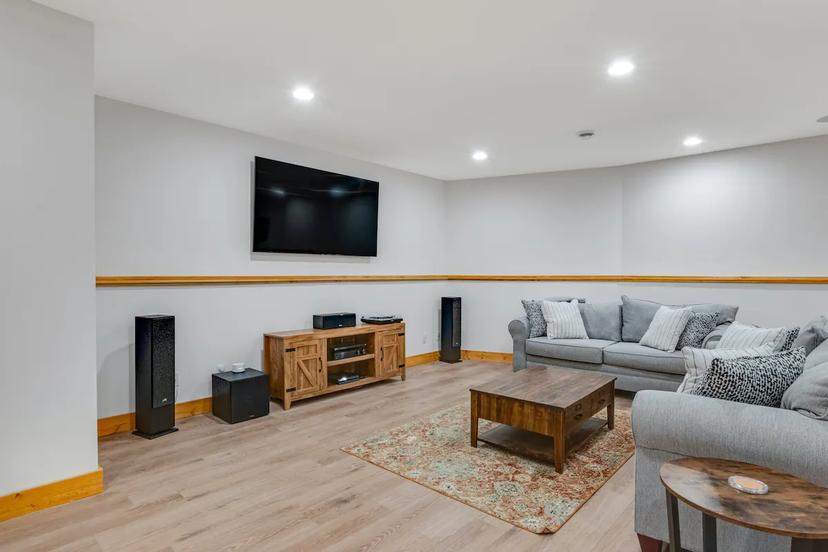 Photo of Living room couches and wooden table, along with a widescreen tv and surround system